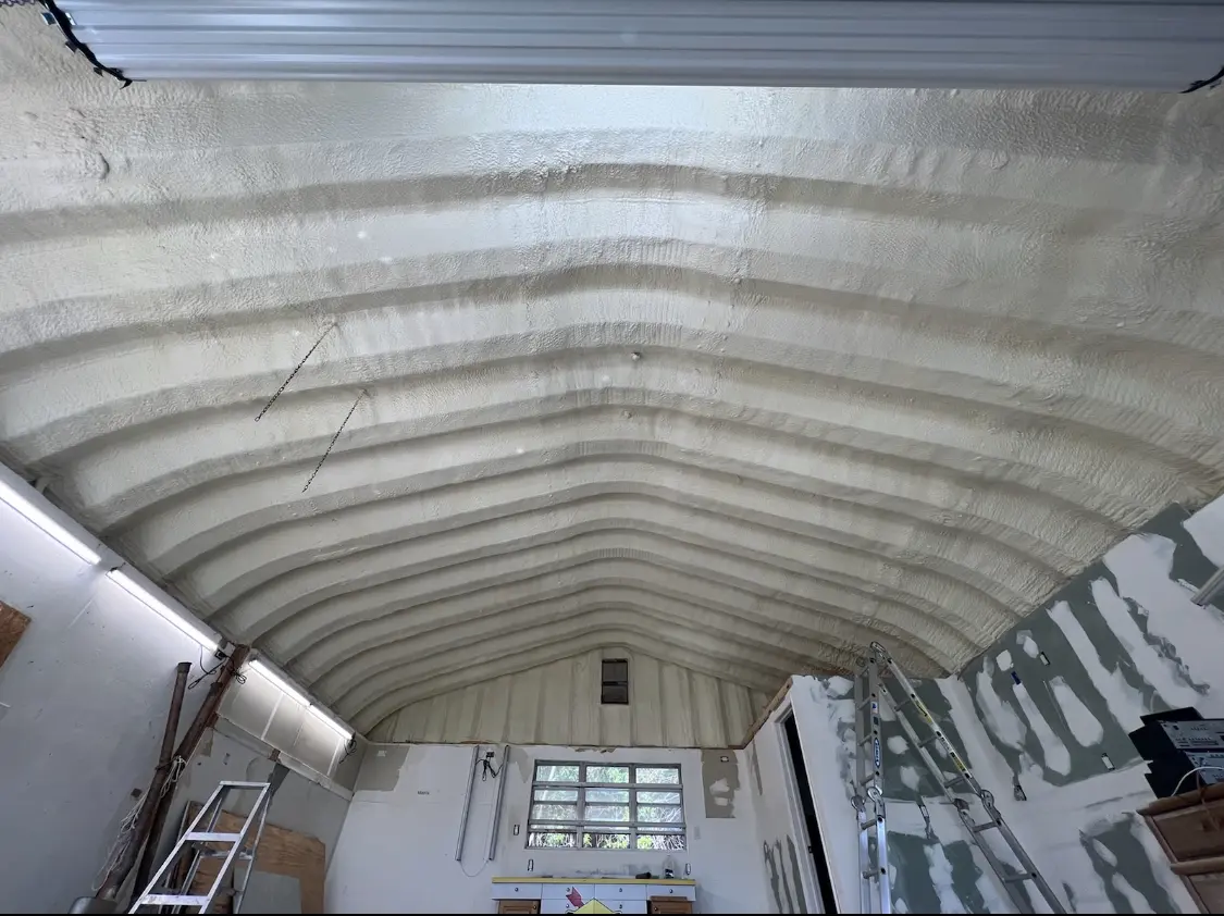 Spray polyurethane foam applied to the underside of a metal roof deck in Conley